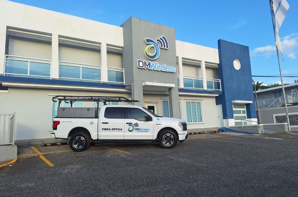 Camión rotulado de DMwireless Fibra Óptica en el estacionamiento de la oficina